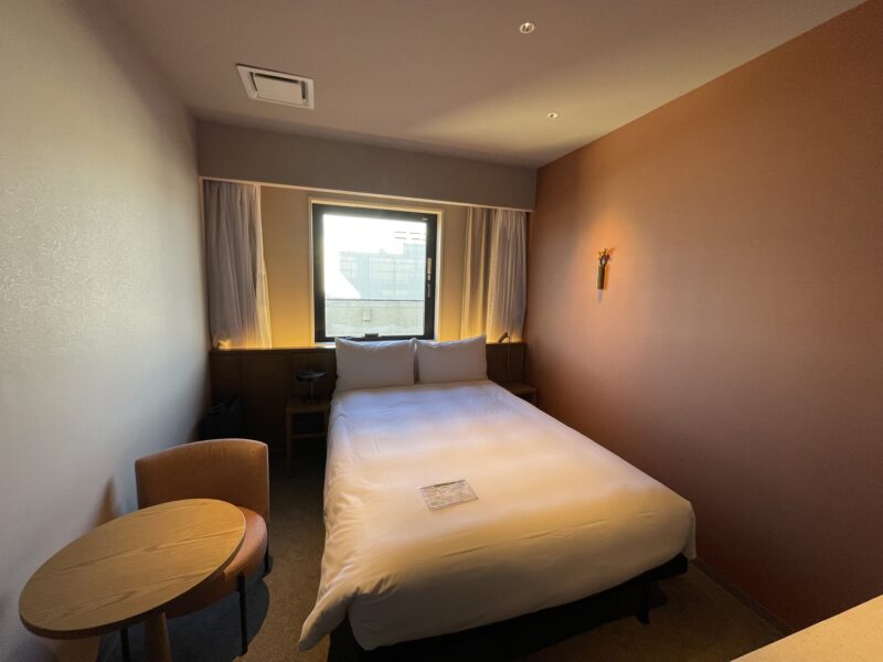 ダブルサイズのベッドが置かれたホテルの一室