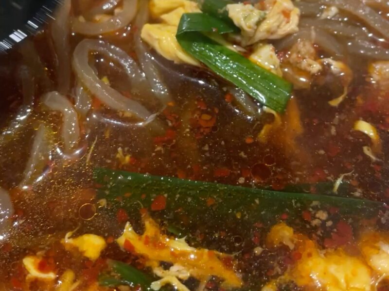 ニラや卵が入った辛麺のスープ