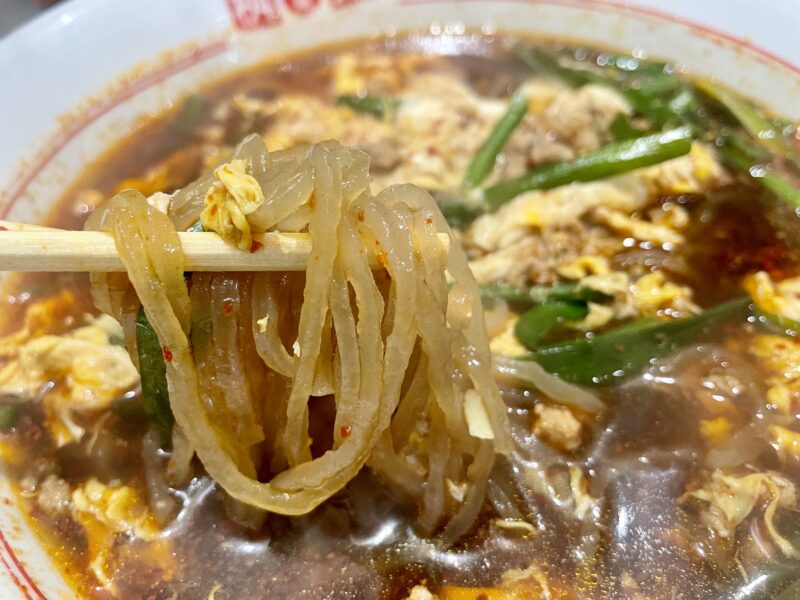 箸ですくった辛麺のこんにゃく麺