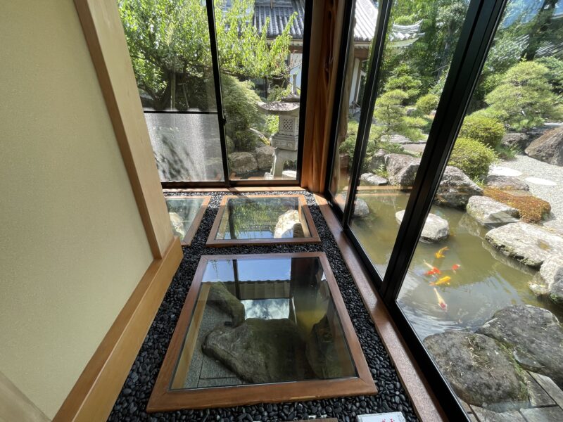 足元がガラスで池が見える廊下
