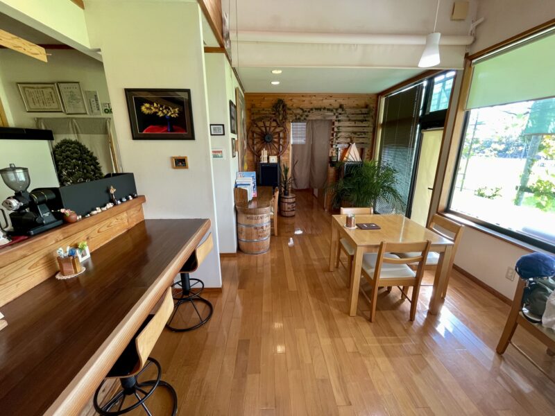 カウンターとテーブルが設置されたカフェの内観