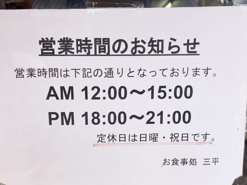 入口に張り紙をされた定食屋さんの営業時間案内