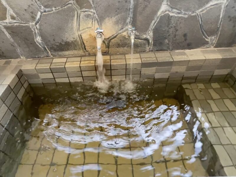 2つの蛇口から湯水が流れている家族湯の湯船