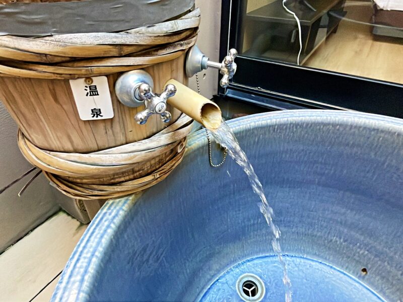 陶器風呂に注がれている温泉のお湯